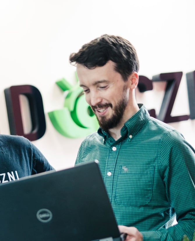 Paweł Więcko z laptopem w biurze agencji widoczni